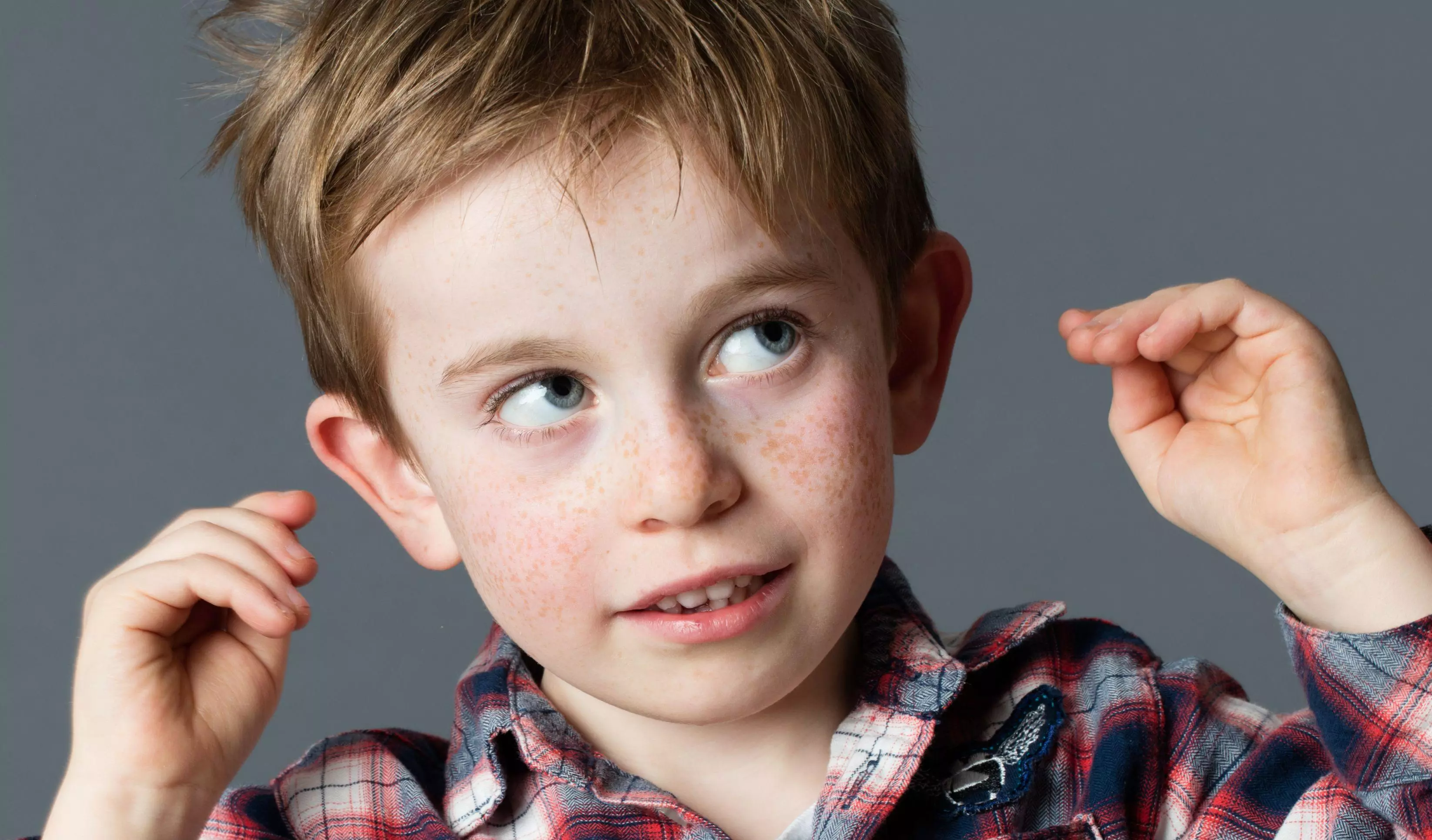Young boy touching ears